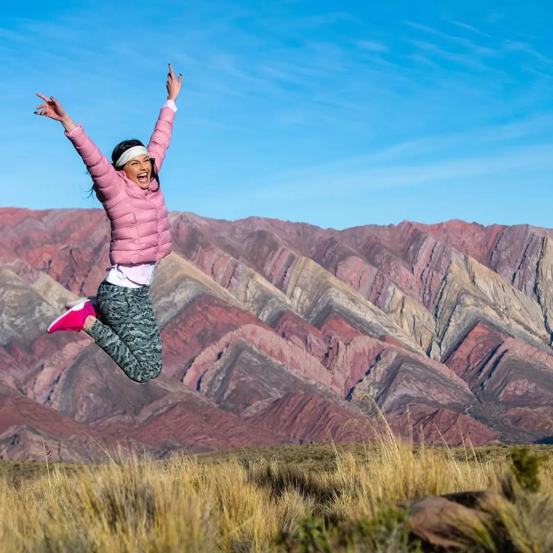 Turista saltando frente al Cerro de los 14 Colores en la excursión 4x4 al Hornocal